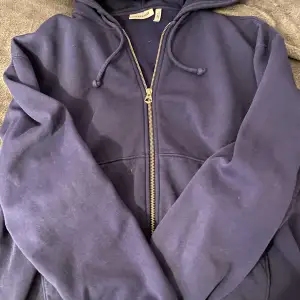 En mörkblå zip hoodie i storlek xs från weekday. Väldigt gott skick och den är endast använd två ggr samt tvättat. Inga defekter. Bild två stämmer överens med dens färg då bild 1 är tagen med blixt