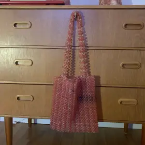 Söt rosa väska gjord av pärlor! Det är några pärlor som har lossnat på ena väskärmen men det syns knappt när man har på sig den. 