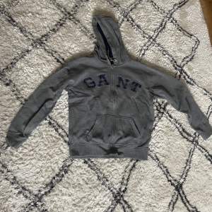 Grå gant zip up hoodie. Storlek small Säljer denna tröja eftersom att det blivit för liten. Finns ett litet hål som jag visar i tredje bilden.