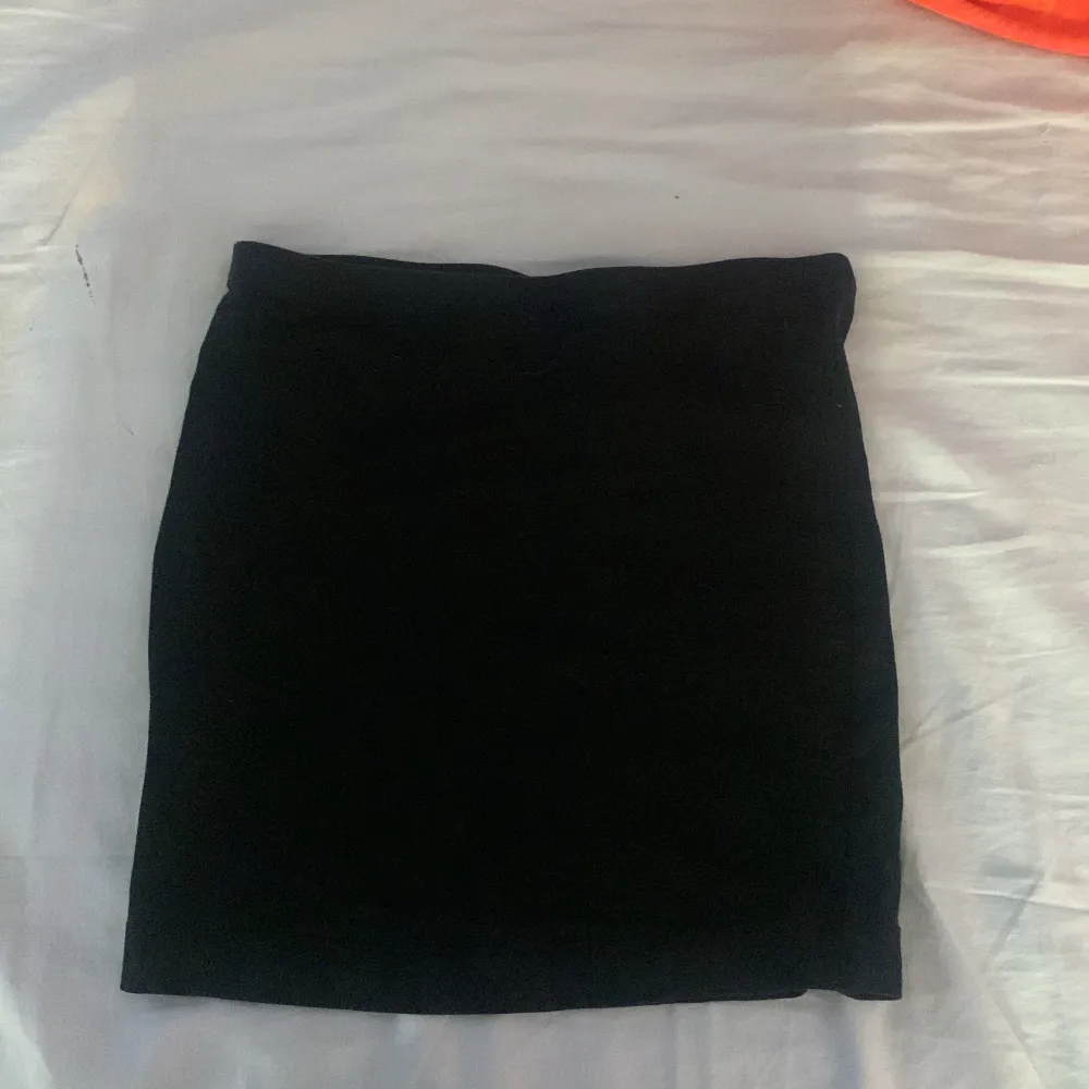 En svart kort kjol i storlek xs. Använd två gånger. Bra skick, inga synliga defekter på den . Kjolar.