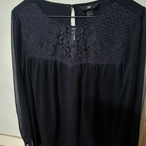 Mörkblå blus - Mörkblå blus från hm i storlek 36, väldigt fin med spets på toppen. Några år gammal så den finns nog inte i butik! 