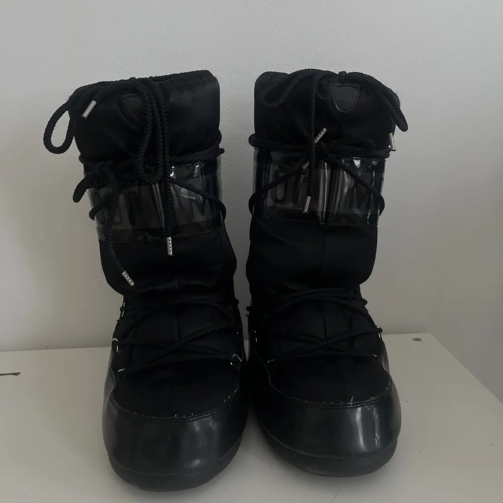Svarta Moon boots med blancka svarta detaljer! Skorna är super sköna när det är snö och lätta. Har använt dom mycket så dom är formade efter foten på insidan. Men utsidan ser dom som nya ut.💗. Skor.