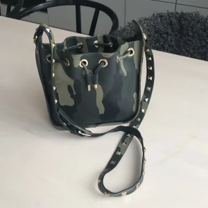 Cool Crossbody kamouflage - Från märket Aurora London. Aldrig använd. Kamouflage mönster, skinnimitation. Mönstret utgått.   Nypris 2200. 