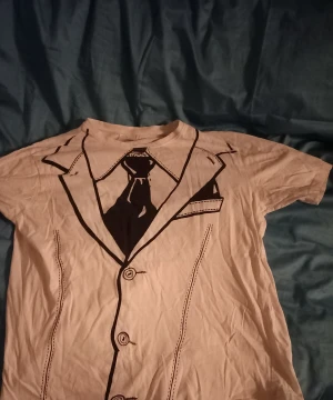 Snygg T-shirt med slips  - Så snygg T-shirt använd få gånger men i fint skick  Katt finns I hemmet men rollar av innan jag skickar 