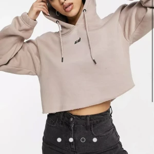 Hoodie - En beige/rosa croppad hoodie från Criminal Damage. Den är använd en gång så den är i väldigt bra skick. Den blir tvättad innan den skickas. Skriv för fler bilder😊