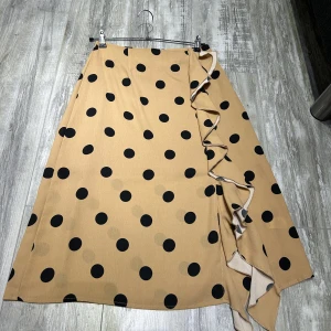 Kjol - En beige svart prikig kjol använd 2 gånger. Normal i storlek och i mycket bra skick.  Passar som vardags kjol eller till en fest. 3/4 i längden.