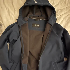 Höst/vår jacka - Säljer denna jacka som är väl använd sparsamt. Passar bra på mig som är 165. Den har inga synliga defekter. Den är perfekt att ha på hösten eller våren. Sitter bra på mig som är 165cm! Den är mörkblå. Osäker på fraktpriset 