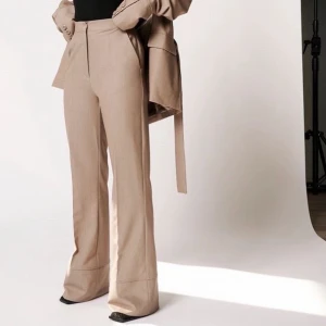 Flared Suit Pants (36) - Hanna Schönberg - Beiga kostymbyxor från en av Hanna Schönbergs tidigare kollektioner tillsammans med NA-KD. Helt oanvända med prislapp kvar i strl. 36. Köptes för 499:- säljes för 300:- finns tillhörande blazer som kan säljas till om intresse finns! Pris kan diskuteras. 