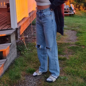 Ripped highwaist jeans - Ett par superfina högmidjade jeans från gina tricot som är ripped på båda knäna. De är köpta för ungefär ett är sedan och är i bra kvalitet!!