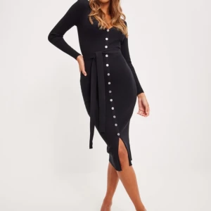 Svart stickad klänning  - Svart stickad klänning från Nelly, endast använd  en gång. 