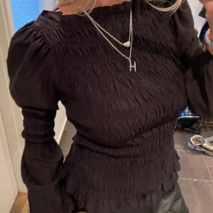 Volang topp - Svart volang och ruffle topp från Neo Noir. Köpt på Nk. Använd fåtal gånger. Storlek XS men stretchig 