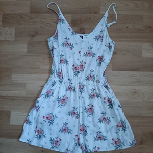 Playsuit storlek 34 - Säljer en vit playsuit med ros mönster från HM i storlek 34. Tunnt och luftigt material 100% viskos. Du står för frakten.