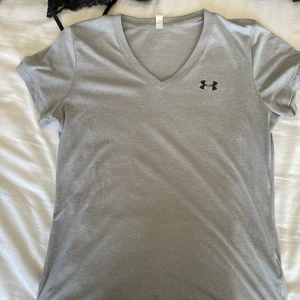 Grå Under Armour T-Shirt  - En bekväm Träningströja från Under Armour. Köparen står för frakt.