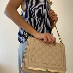 En baech väska - Den baech väska som aldrig har används. Väskan går att ändra längden och har guld skedja. Det finns mycket plats inne i väskan.