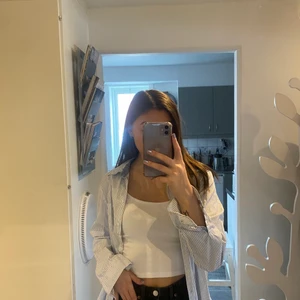 Vit skjorta med blåa ränder - Använd fåtal gånger. Säljer då den inte kommer till använing längre storlek 40 men passar mig som brukar ha S.