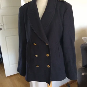Burberry Brit skepparjackaStorlek Italie - Jättesnygg navyblå  skepparjacka från Burberry Brit.. Italiensk storlek 48, som motsvarar en 44a. Stängs med dubbla rader knappar. jackan har insticksfickor. bra bruksskick. Material: 7`% ull, 25% polyamide och 5% cashmere.