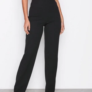 Svarta byxor  - Svarta byxor från NLY TREND. Långa i benen. Snygg passform. Sitter åt på rumpan och i midjan men är lösa och raka i modellen på benen. Endast använd 2 gånger. Stretchigt och följsamt i materialet.