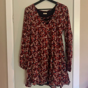 Somrig blommig klänning från Hollister. - En superfin blommig klänning från Hollister. Knytning vid urringningen. Jätteskönt och mjukt material. Aldrig använd så i väldigt bra skick. Storlek M men skulle nog även passa en S. Frakt tillkommer💋 