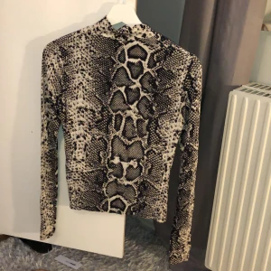 Tröja i snake mönster stl S - En turtel neck tröja i snake mönster med ett väldigt skönt material. Stl S