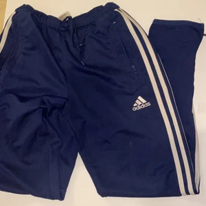 Adidasbyxor  - Mörkblåa adidiasbyxor med dragkedja vid ficka och byxänden. Bra skick!