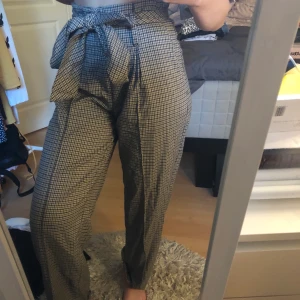 Rutiga byxor - Utsvängda rutiga byxor från bikbok. Knyts i midjan, har även en dragkedja. Aldrig använda. Storlek xs, passar s. Frakt tillkommer. Skicka meddelande för mer bilder