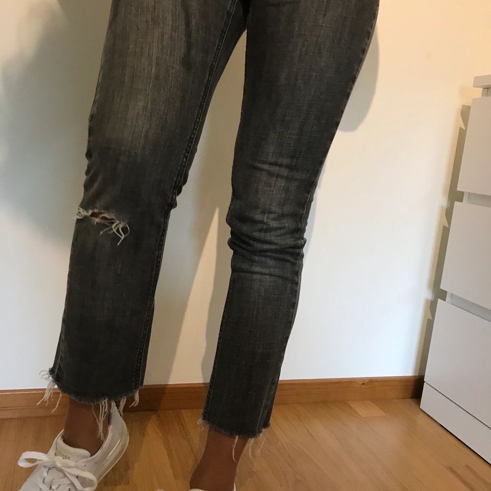Gråa skitsnygga jeans från ginatricot med hål i ena knäet och slitningar längst ner på byxbenen. Köparen står för frakt som är cirka 80kr eller mötes upp i Borås.. Jeans & Byxor.