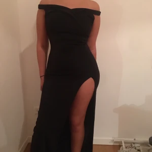 Off-shoulder klänning - Svart off-shoulder klänning, storlek 36, lång så att den går ner till över fötterna, har en slit, köpt online, säljer då den inte kommer till användning🌸