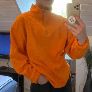 Orange polosweatshirt - En sweatshirt med dragkedja upp till polokrage. Oversized S i herrstorlek som sitter sjukt snyggt och av bekvämt material. 