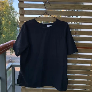 Blus från Carin Wester storlek 38 - Svart t-shirt-blus från Carin Wester. Säljes pga för liten. Knapp bak. — FRAKT INGÅR —