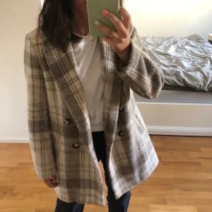 Rutig kappa  - Säljer denna fina kappa, storlek 36. Den är använd ett fåtal gånger och är i mycket fint skick. Frakt tillkommer🥰