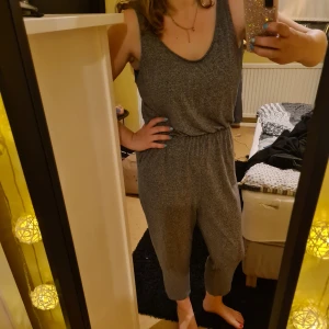 Lång grå jumpsuit. - Storlek L ifrån HM, använd fåtal gånger. Katt finns i hemmet 