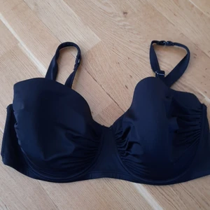 Twilfit bikini strl 85F - Svart bikiniöverdel från twilfit. Den har avtagbara axelband och jag har sytt lite i fästet för att banden ska sitta bättre. Bikiniöverdelen är använd ett fåtal gånger och är i gott skick!