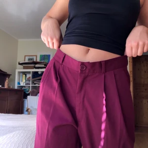 Vinröda / mörklila kostymbyxor - Vinröda / lila kostymbyxor, fint skick (färg mest likt bild 3). 2 fickor framtill, 2 fejkfickor baktill. Stängs med dragkedja och knapp. Säljs pga att de är alldeles för stora.