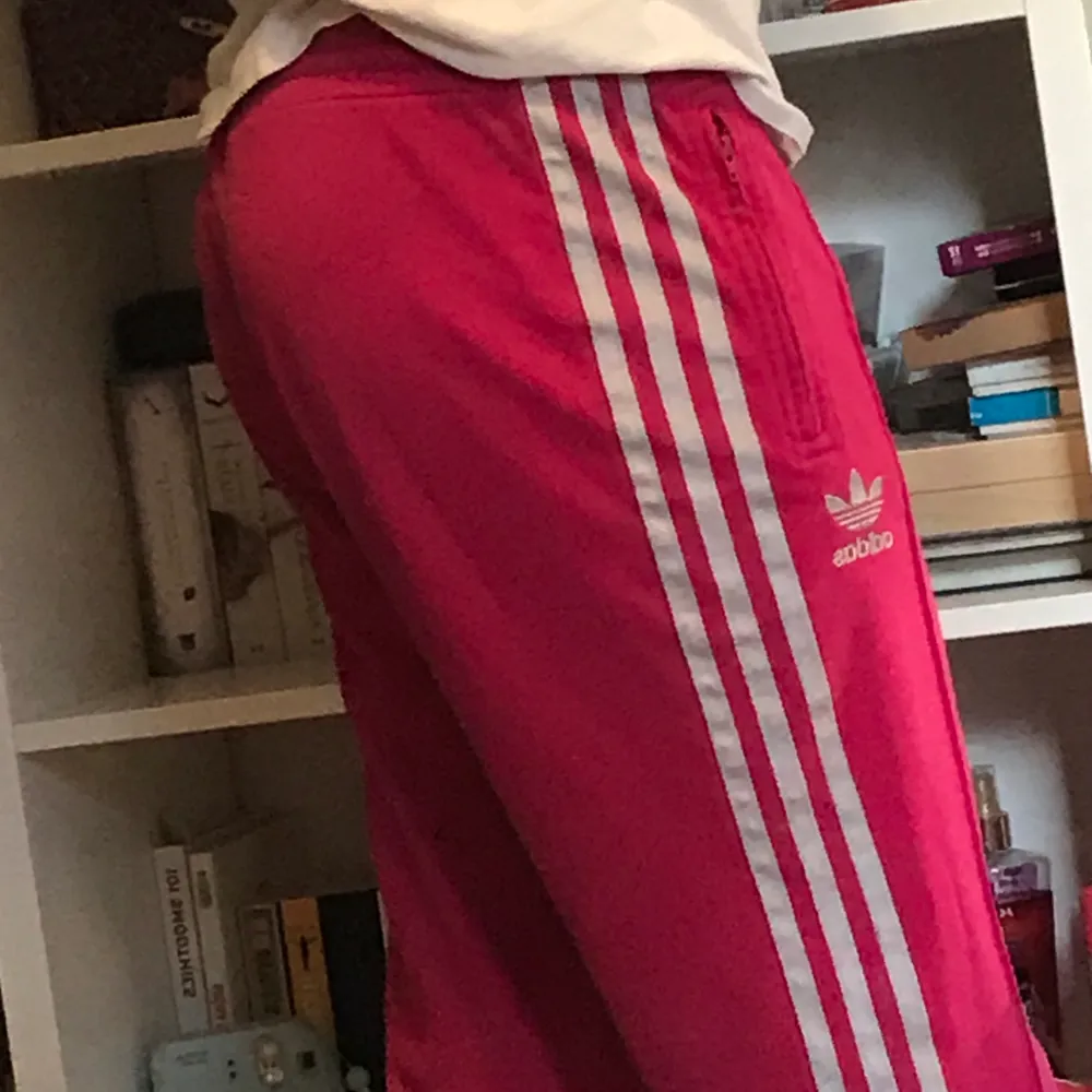 Svincoola rosa Adidasbyxor som inte kommer till användning längre. Byxorna är lite smått slitna men det syns knappt.. Jeans & Byxor.