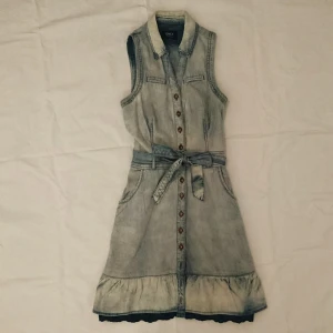 Jeansklänning  - Söt jeansklänning med marinblå spets nedtill. Knappar hela vägen och skärp i midjan. Två fickor vid höften. Frakt ingår i priset 💃 Står 36 på lappen men funkar även för 38
