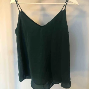  - Oanvänt linne i polyester. Väldigt fint fall!