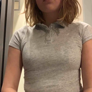 Pikétröja  - En gråmelerad pikétröja från Hollister. (Det gula sträcket på bilden är bara ljuset). Strechig och perfekt basic plagg att ha i garderoben! Stl XS men passar även en S beroende på passform. Använd ett fåtal gånger. 10kr+frakt 30kr