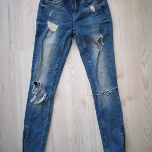 Kristen jeans  - Kristen jeans med slitningar och dragkedja längst ner 