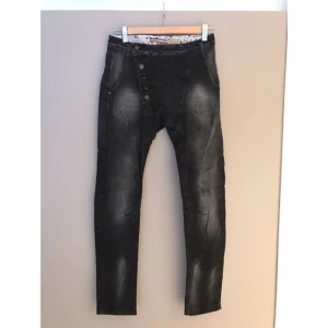  - Please-jeans med lite "häng" och sned knäppning framtill. Sparsamt använda i mycket fint skick. Nypris 1500 kr.