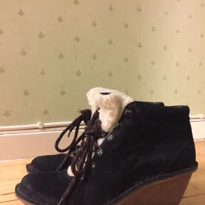  - Svart känga med kilklack i retrostil. Skinn med gummisula och Teddy fodrad längs övre kanten. Klacken är ca. 5,5 cm och bred. Storlek är EU 39 som har en vanlig passform. Inte mycket använt, rena och hela.