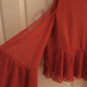  - Blus med vida räfflade ärmar från Nelly. Färgen är en rödorange blandning. Skitsnygg på kroppen! Frakt på 20kr❤🌹