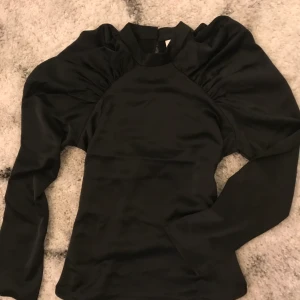 Silkesaktig topp/blus med puffärmar - Superfin blus i silkesaktigt material med puffärmar. Helt oanvänd, prislapp kvar, strl S. 50kr eller högsta bud. Säljer snarast