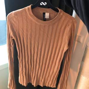 Ribbad tröja från H&M i en fin beigebrun färg (bild 2), normallång med en kortare slits i sidorna och lite utsvängda ärmar. Storleken är mellan xs/s. 60kr inklusive frakt🥰