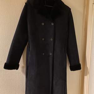 En mörk blå lång kappa i storlek 38. Pris: 200kr. Köparen står för frakten. 