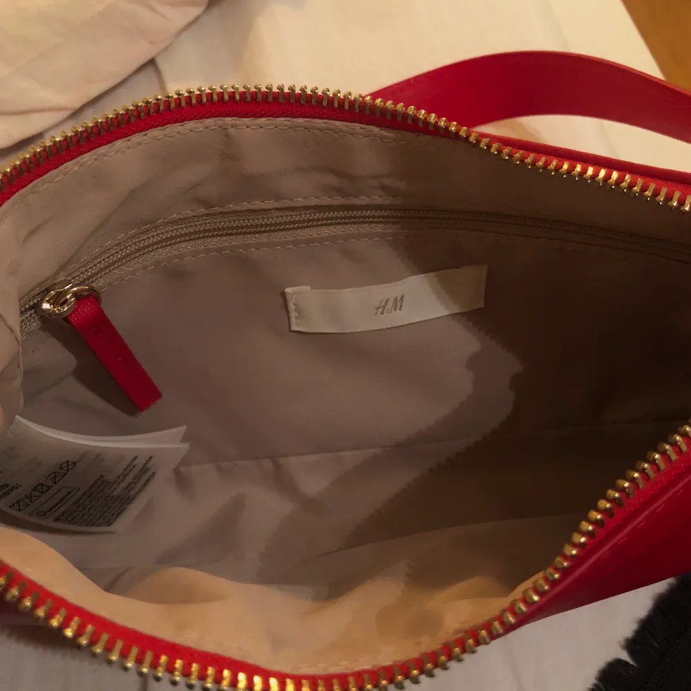 Superfin röd väska med gulddetaljer från H&M! Använd fåtal gånger därmed i gott skick. Frakt tillkommer och betalningen sker via Swish!. Accessoarer.