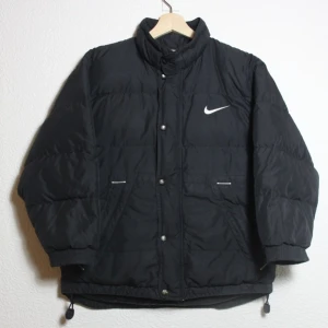 NIKE jacka stl M - Svart jacka fr Nike storlek M söker nytt hem! Så sjukt snygg. Har kortare ärmar. Den är lite sliten insida ärm och muddar, har bilder så bara att fråga så skickar jag. Även själva hänget till blixtlåset är borta. Axel  till ärm är d ca 49 cm ca 80kr frakt