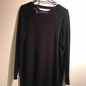  - Svart klänning med glitter och djup rygg. Använd Max 5ggr.  Passar från storlek M skulle jag säga beroende på hur man vill att den ska sitta  