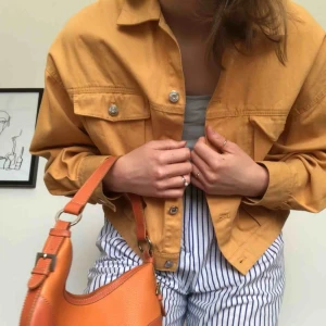 Orange vårjacka strl S - Så fin croppad vårjacka från weekday! Orange/aprikosfärgad i jeansliknande material