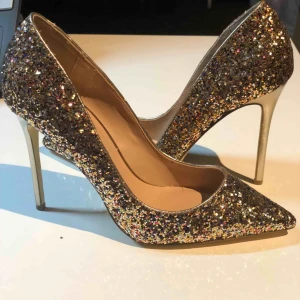  - Supersnygga festskor från River Island (har endast provat dem inomhus) med fina glittriga detaljer. Strl 38 och höga klackar. Hämtas Odenplan, Stockholm eller posta mot fraktkostnad 69kr, som betalar av köparen. OBS! Fraktkostnaden ingår ej i varans pris!