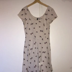  - Klänning i trikå från H&M med fint fågelmönster. Knappt använd. Strl 38.